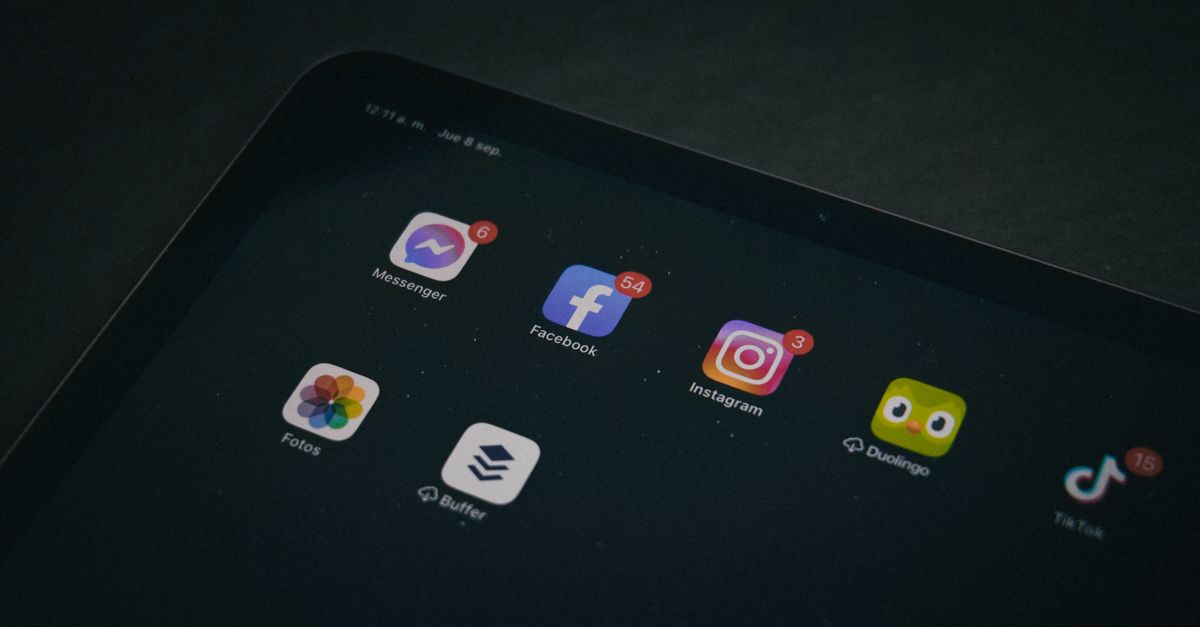 Búsqueda social: cómo encontrar reseñas útiles en TikTok, Instagram y YouTube sin caer en publicidad social media technology: A tablet displaying popular apps like Facebook and Instagram in a dimly lit setting.