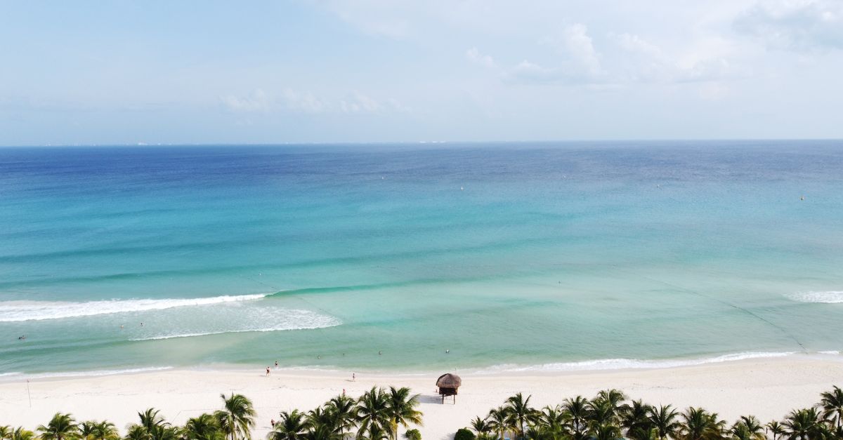 las playas más hermosas del mundo: Stunning aerial view of a tropical beach in Playa del Carmen, Mexico with azure waters and palm trees.