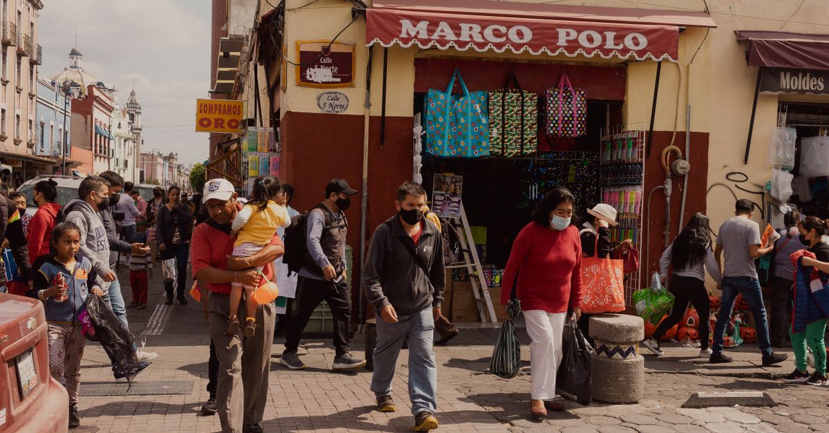 Cómo usar asistentes de IA para comparar compras sin delegar tus decisiones importantes tecnología moderna: Lively street scene in Puebla, Mexico, capturing urban life with people shopping and walking.