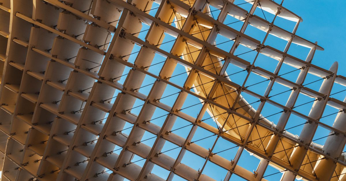 beneficios de la arquitectura sostenible: Abstract view of the Metropol Parasol in Seville featuring unique wooden design against a clear blue sky.