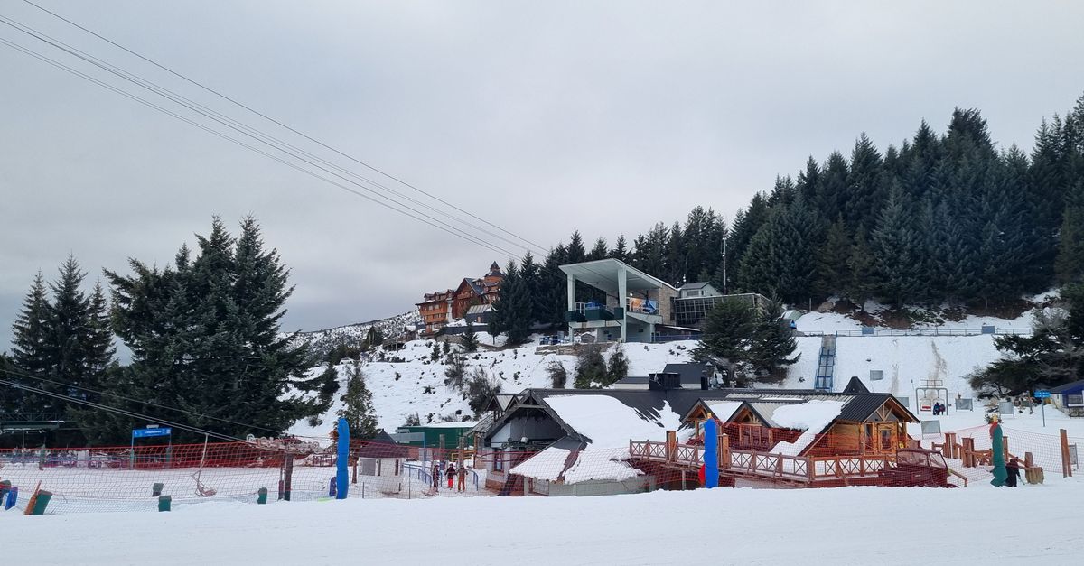 pistas de ski en julio, dónde ir: Scenic winter view of a ski resort with cabins and snowy terrain.