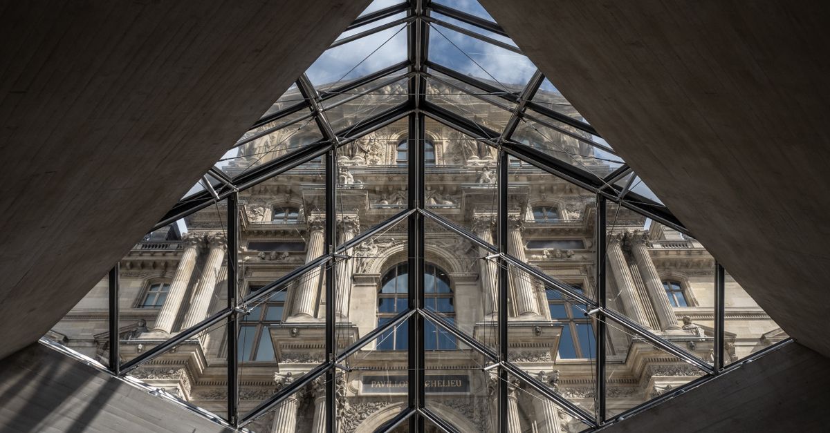 plataformas web de viajes con ofertas para viajar: View of the Louvre Museum through the iconic pyramid structure in Paris.