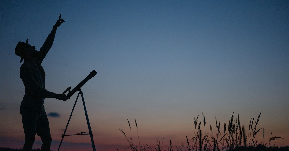 Calendario de eventos astronómicos de 2026 y consejos para observarlos con seguridad ciencia investigación: Silhouette of a person pointing at the sky with a telescope during twilight.
