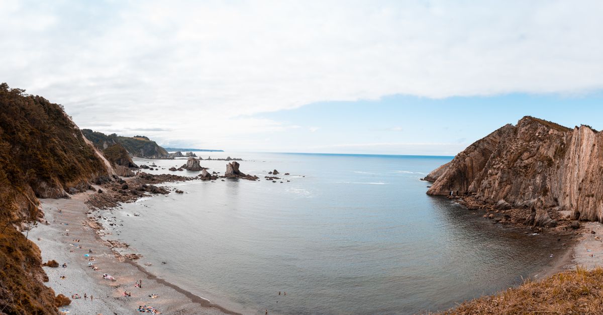 las playas más hermosas del mundo: A panoramic view of Playa del Silencio featuring cliffs and the ocean in Spain.