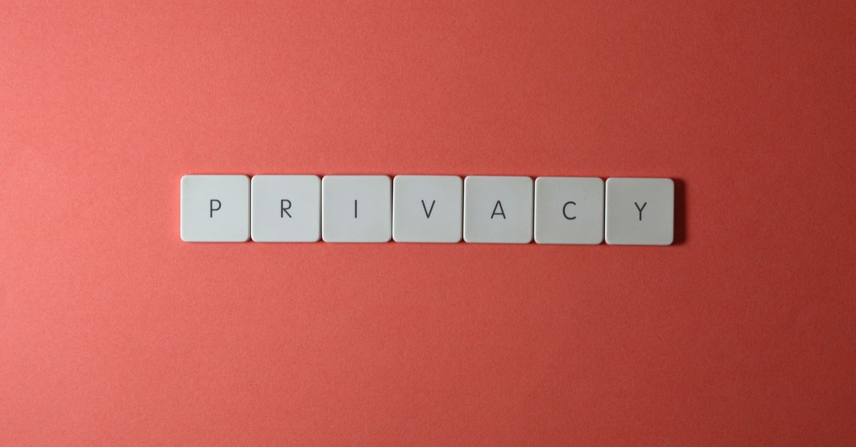 Cómo proteger privacidad usar: Close-up of letter tiles spelling PRIVACY on a red background, symbolizing data protection.