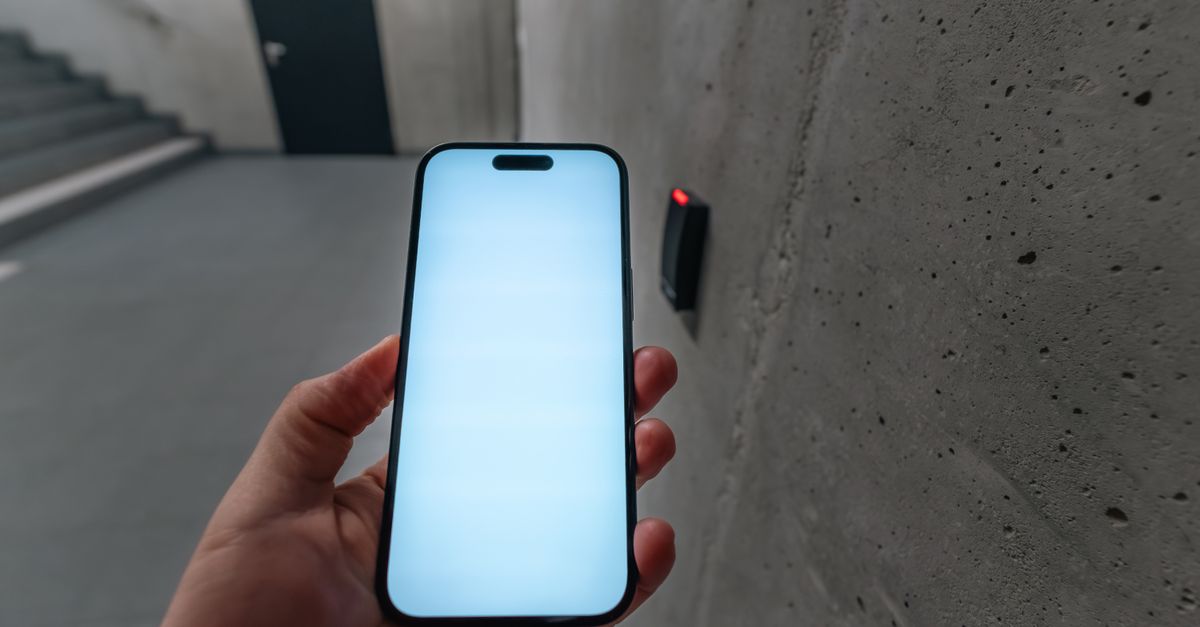 Cómo elegir un smartphone con IA en 2026 sin sacrificar privacidad ni control tecnología moderna: A smartphone unlocking a secure door using NFC technology in a modern building stairwell.