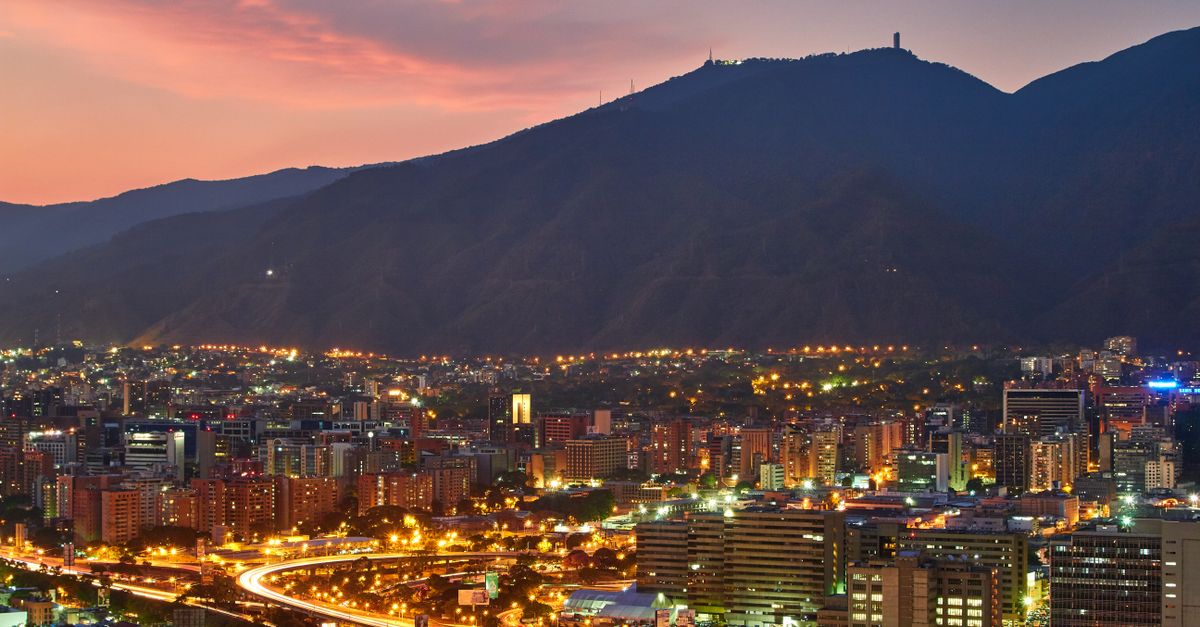 Ciudades más calurosas: hábitos y soluciones domésticas para reducir el calor urbano bienestar practico educational neutral health: A stunning aerial view of Caracas cityscape at dusk, showcasing the vibrant city lights against the mountainous backdrop.