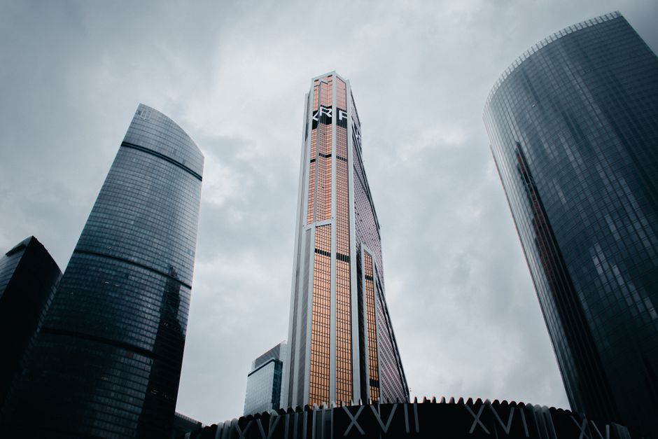 Tall skyscrapers dominating the Moscow City skyline against a cloudy sky.